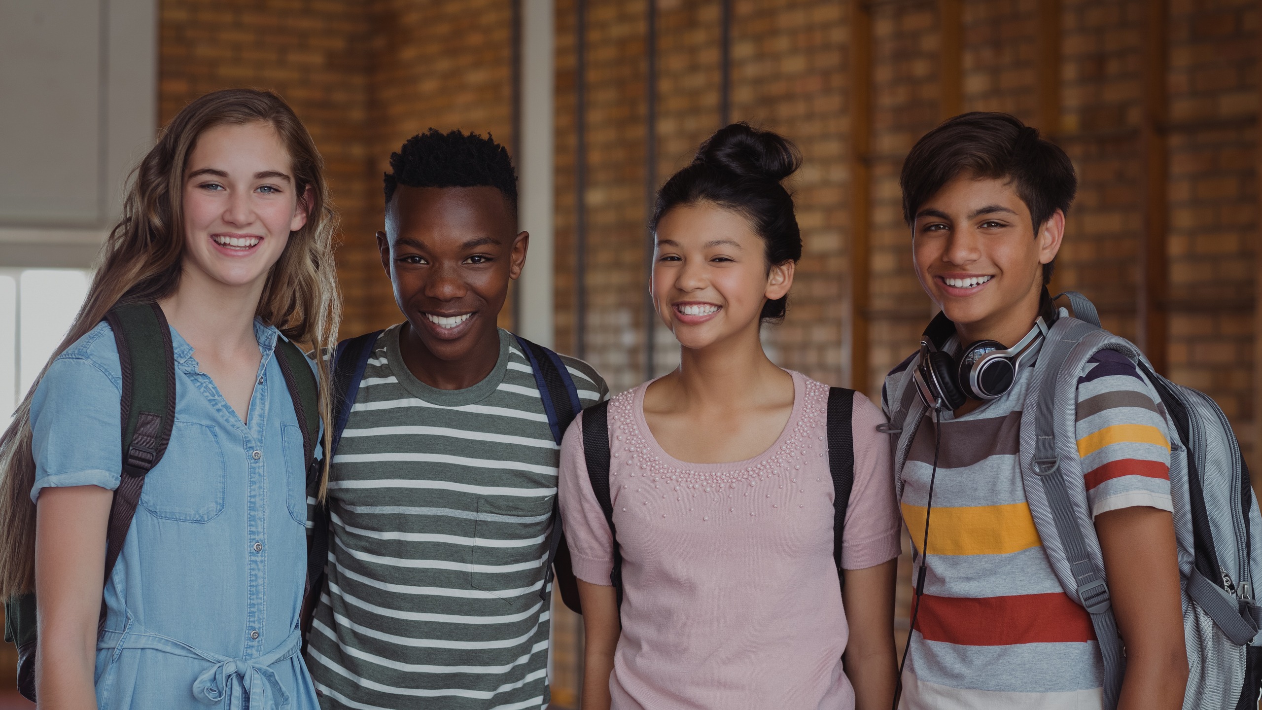 Four diverse high school students standing together